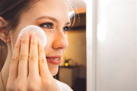 Close Up Side View Of Young Woman Removing Make Up Off Her Face Using A