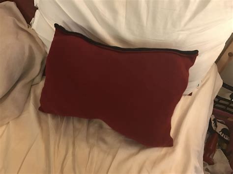 A Red Pillow Sitting On Top Of A Bed