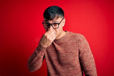 Young Handsome Hispanic Man Wearing Nerd Glasses Over Red Background