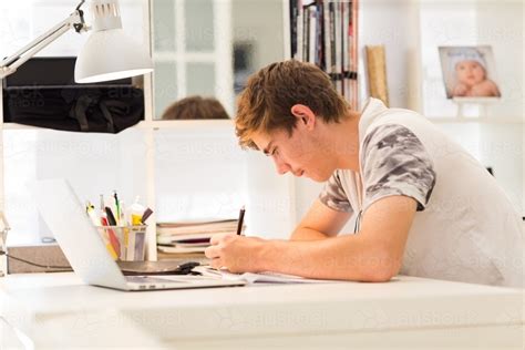 Image Of Teenage Boy Writing At A Desk Austockphoto