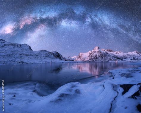 Milky Way Above Frozen Sea Coast And Snow Covered Mountains In Winter