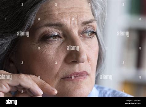 Pensive Mature Grey Haired Lady Looking Away In Deep Thought Stock