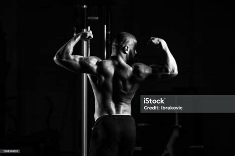 Handsome Muscular Man Flexing Muscles In Gym Stock Photo Download