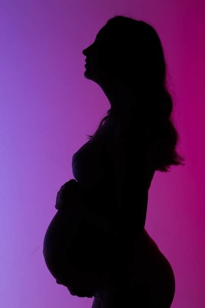 bela jovem grávida em lingerie e linda luz neon foto premium