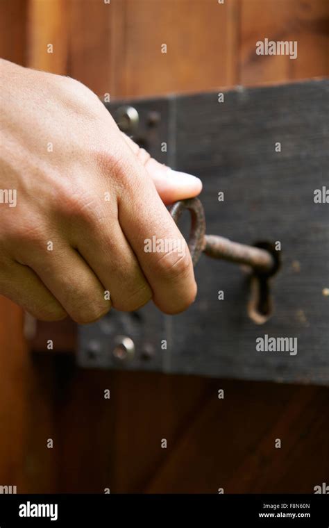 Hand Turning Key In Old Fashioned Lock Stock Photo Alamy