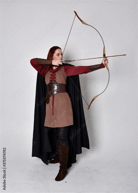 Full Length Portrait Of Girl With Red Hair Wearing Medieval Archer