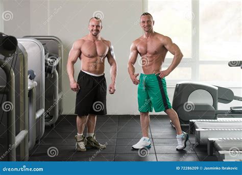 Two Muscular Men Flexing Muscles In Gym Stock Image Image Of Muscles