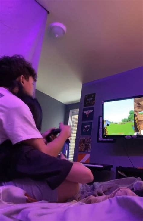 Two People Playing A Video Game On The Nintendo Wii In A Bedroom With