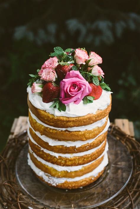 simple naked wedding cake with flowers and berries