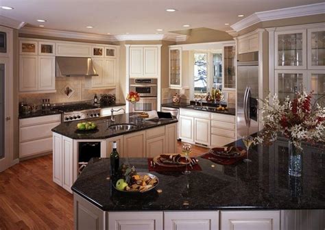 Two black iron pendant lights contribute to the traditional country charm vibe. White Kitchen Cabinets with Black Granite Countertops - Home Furniture Design