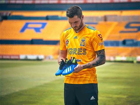 Camiseta naranja con detalles negros, pantalón y medias negras. Tigres presume su nueva piel | Excélsior