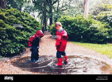 niños jugando en charcos de lluvia fotografías e imágenes de alta resolución alamy