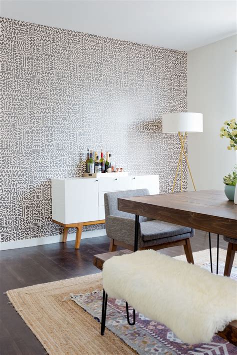 A Dining Room With A Wallpaper Accent Wall And Layered Rugs Wallpaper