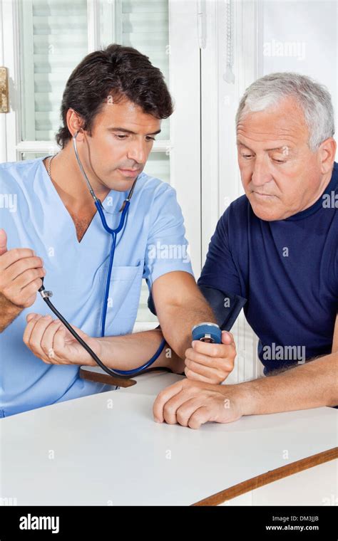 Male Nurse Checking Blood Pressure Of A Senior Man Stock Photo Alamy