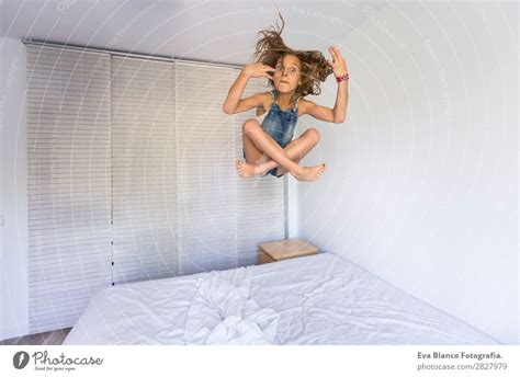 schönes Kind Mädchen beim Spielen und Springen auf dem Bett ein lizenzfreies Stock Foto von