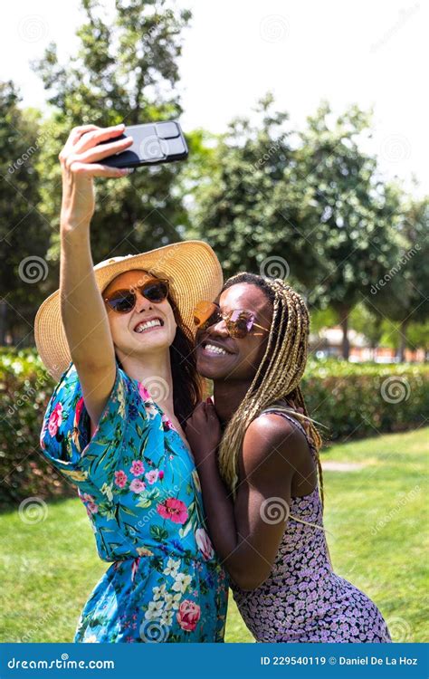 Young Multiracial Lesbian Couple Take Selfie In The Park During Vacation Vertical Image Stock
