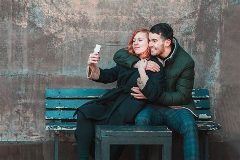 Casal Jovem Emocional Alegre Sentado No Banco E Fazendo Selfie Duas