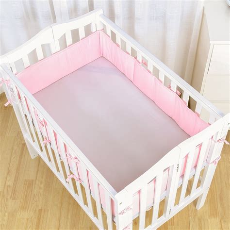 A White Crib With Pink Sheets On It