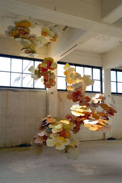 An Art Installation Made Out Of Paper Flowers Hanging From The Ceiling