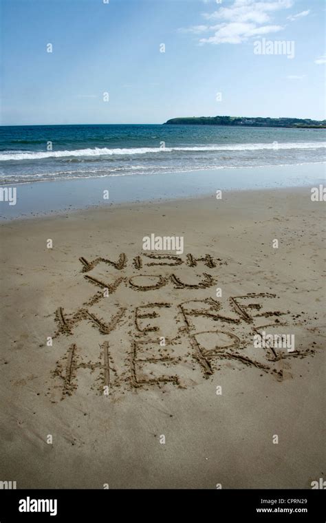 Message Written Into The Sand On A Beach Wish You Were Here Stock