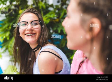happy teenage mädchen mit zahnspange und brille betrachten freund stockfotografie alamy