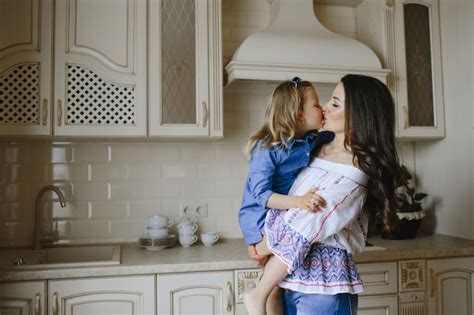 Free Photo Mom Kisses A Little Daughter In The Kitchen