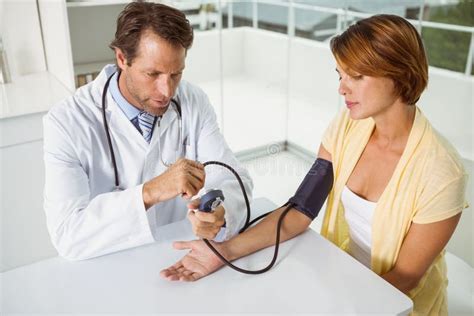 Doctor Checking Blood Pressure Of Woman At Medical Office Stock Image