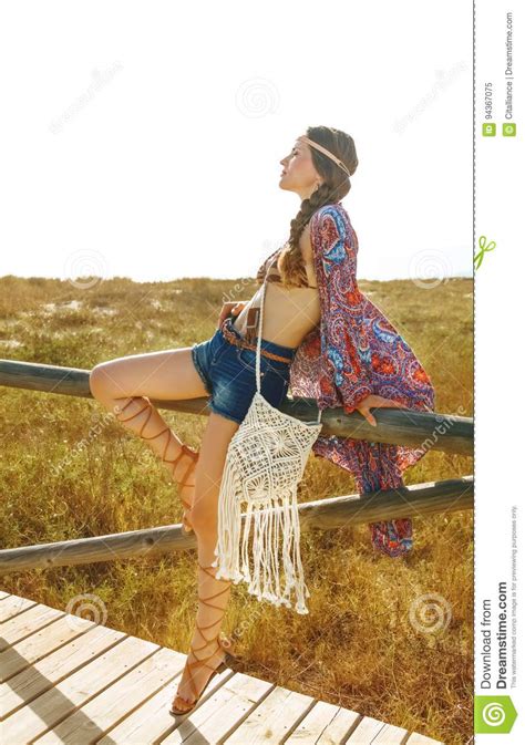 Longhaired Hipster Outdoors In Summer Evening Sitting On Fence Stock