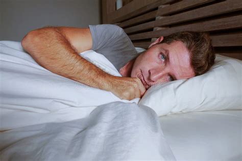 Restless Worried Young Attractive Man Awake At Night Lying On Bed Sleepless With Eyes Wide