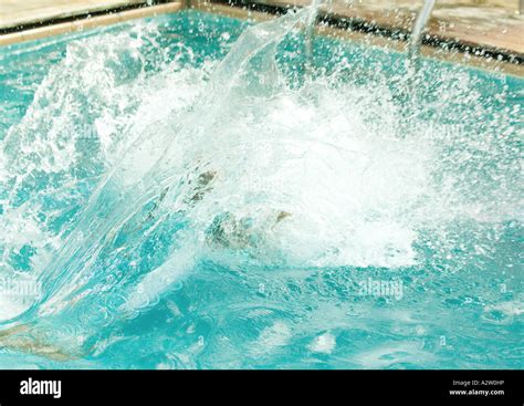 Water Splashing As Person Jumps Into Pool Stock Photo Alamy