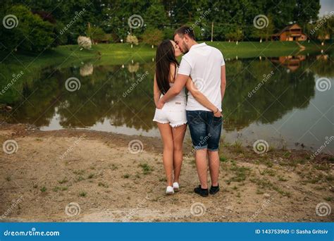 Photo Of Back Couple Hold Heir Hands In Back Pockets Stock Photo