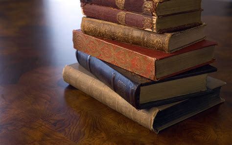 A Stack Of Old Books On A Wooden Surface Wallpapers And Images