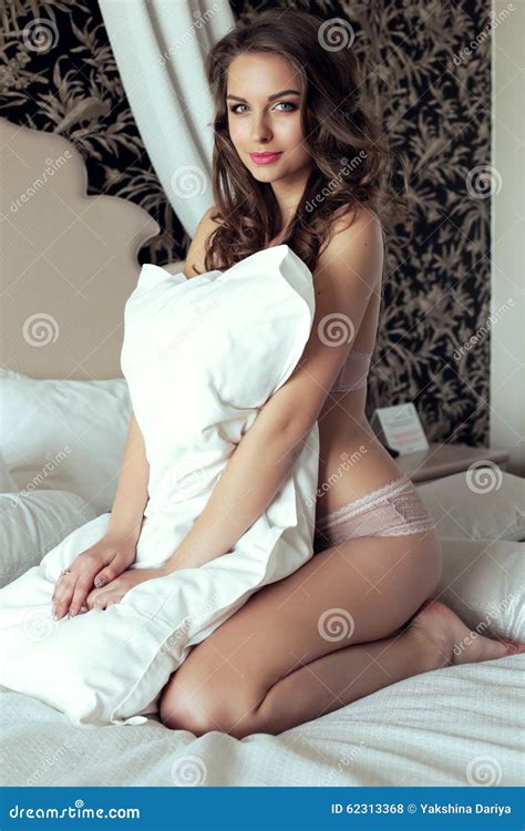 Beautiful Girl With Long Dark Hair Posing In Bedroom Stock Photo