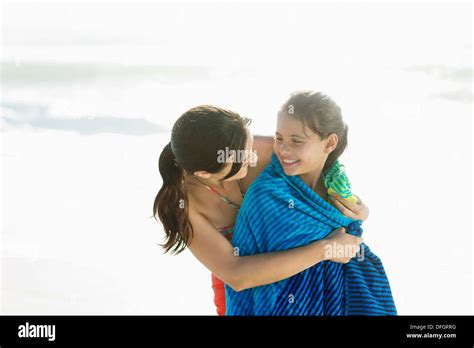 Mother Wrapping Daughter In Towel On Beach Stock Photo Alamy