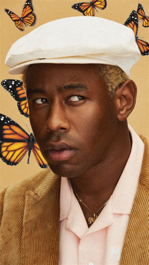 A Man Wearing A Hat With Butterflies On It