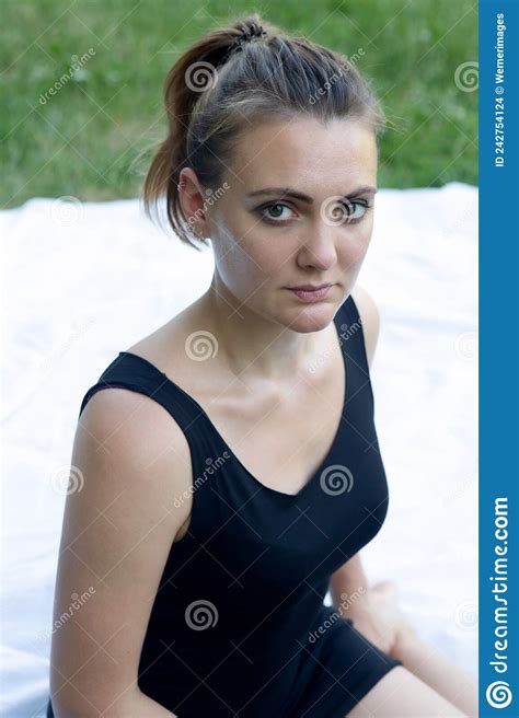 Portrait Of Young Woman Sitting Outdoors On White Blanket Stock Photo
