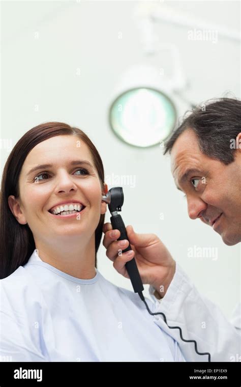 Doctor Using An Otoscope To Look At The Ear Of A Patient Stock Photo