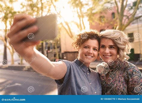 Pares Lesbianos Sonrientes Que Toman Un Selfie Junto En La Ciudad Foto De Archivo Imagen De
