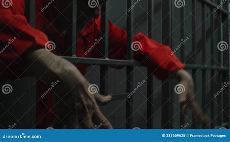 Tired Inmate Stands Behind Bars in Jail or Detention Center Stock Video