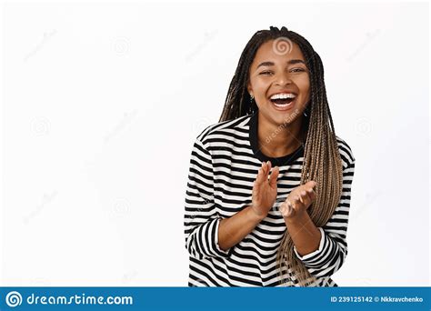 happy black girl laughing and smiling applausing clap hands and looking joyful standing over