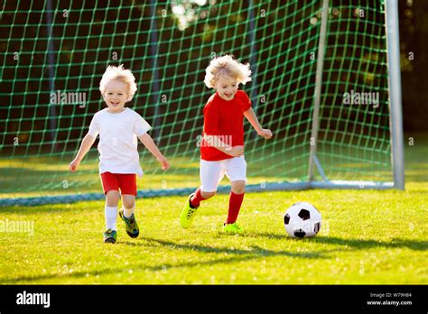 Kids Play Football On Outdoor Field Children Score A Goal At Soccer