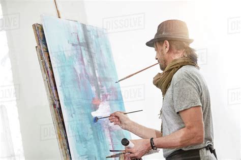 Male Artist Painting At Easel In Art Studio Stock Photo Dissolve