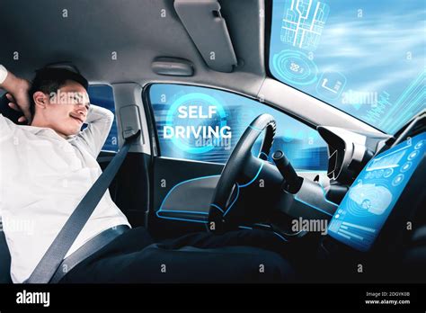 Self Driving Autonomous Car With Relaxed Young Man Sitting At Driver Seat Is Driving On Busy