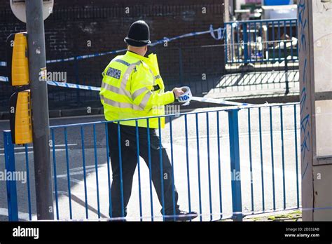 West Midlands Police Officer Rolling Out Police Tape On Upper Dean