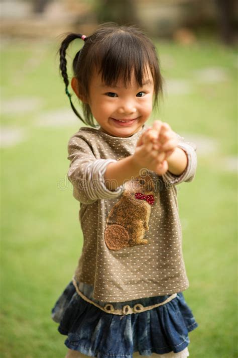 5 Year Old Chinese Asian Girl in a Garden Making Faces Stock Image ...