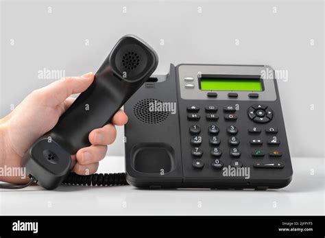 Hand Holding Voip Telephone Receiver On Gray Background Dialing