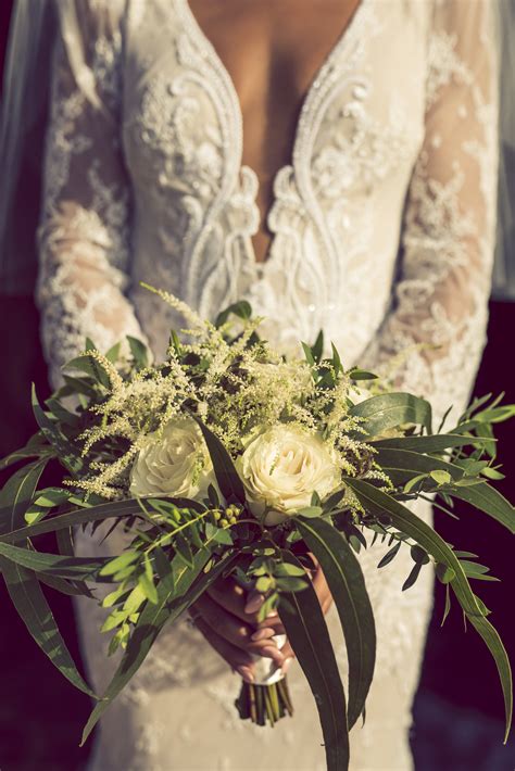 Simple Bridal Bouquet With White Roses And Lots Of Foliage Tied With A