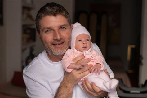 Lifestyle Portrait Of Attractive And Happy Man Holding His Baby Girl In