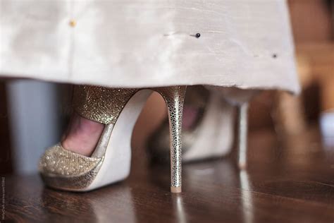 Women S Feet In Sexy Gold Heels Peek Out From Hemline By Stocksy Contributor Holly Clark