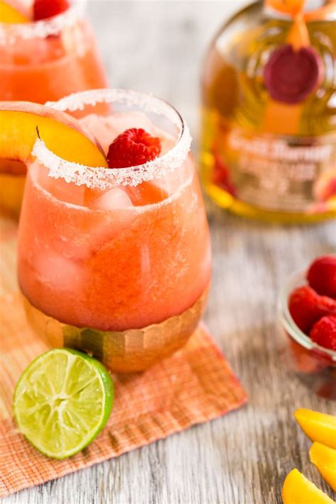 Two Raspberry Peach Margaritas With Fresh Fruit Peach Margarita Fruity Margarita Recipe